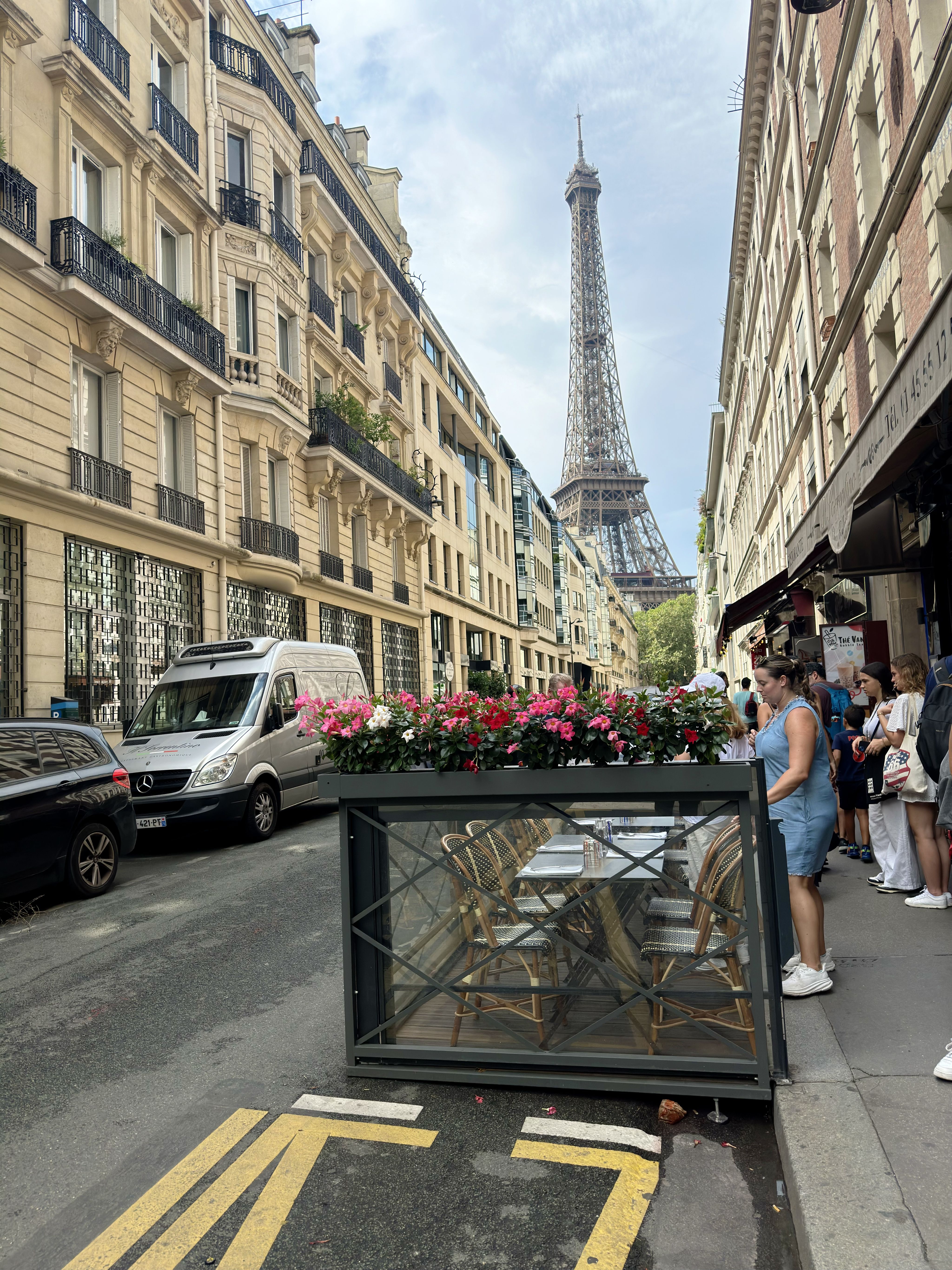 A photo of a street scene in Paris with the Eiffel Tower in the background